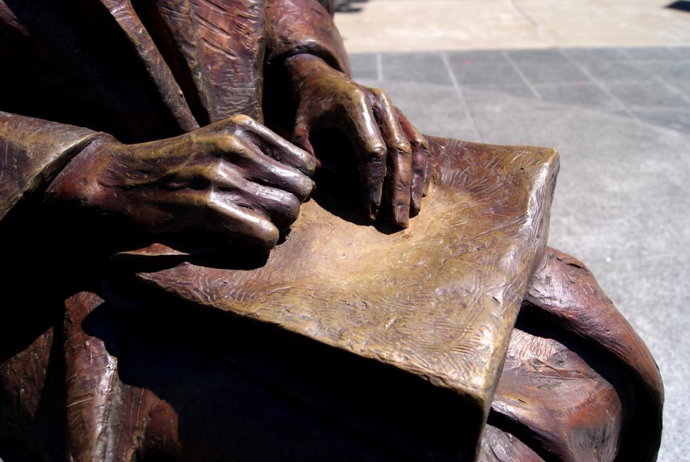 Free Image of Bronze statue of a women sitting with a book 