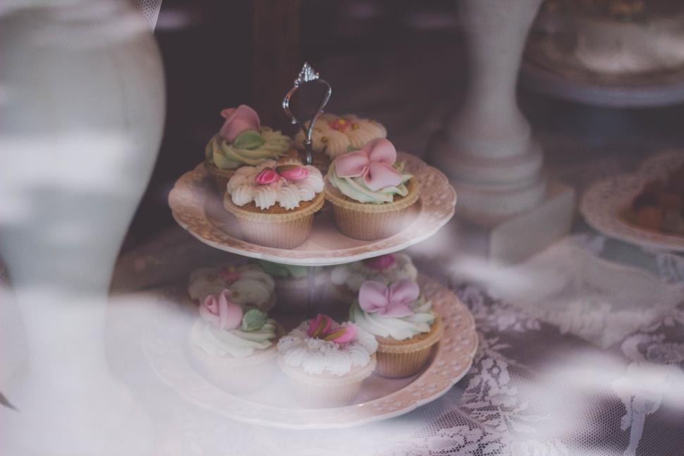 Free Image of Elegant cupcakes displayed on a stand with soft lighting. 
