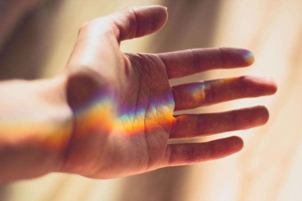 Free Image of Hand catching light with a rainbow spectrum overlaid 