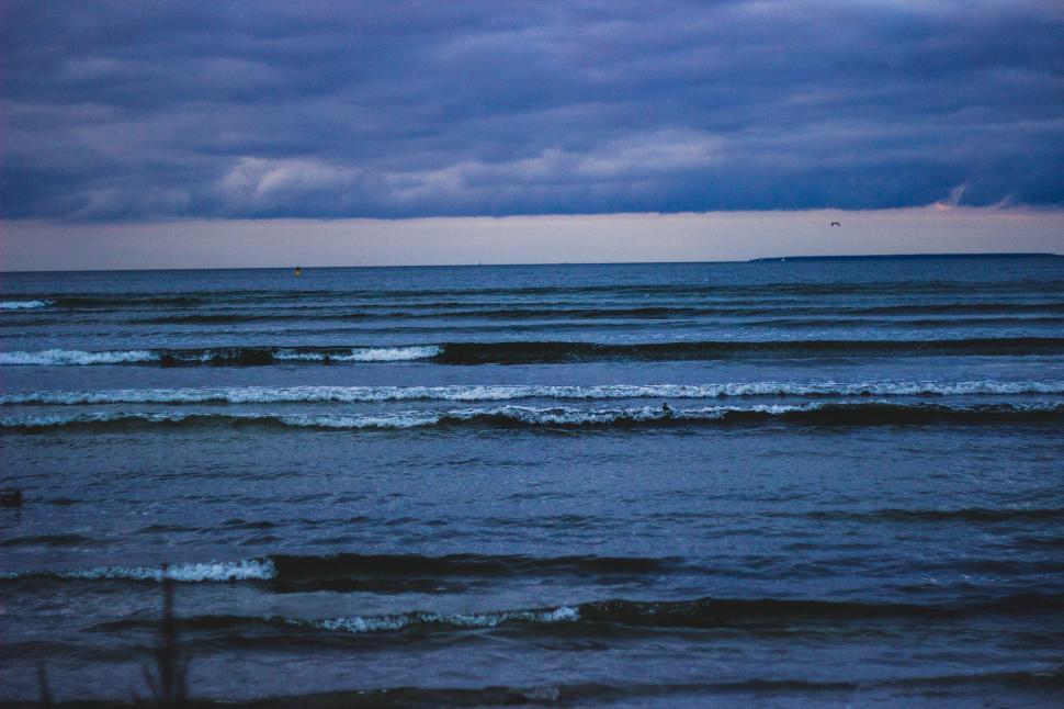 Free Image of Dark ocean waves under cloudy sky during twilight time. 