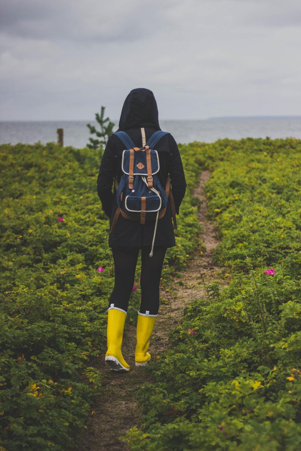 Free Image of Person walking path with yellow boots near the sea 