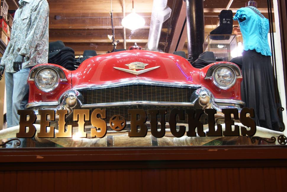 Free Image of Belts and Buckles store front with old car in the window 
