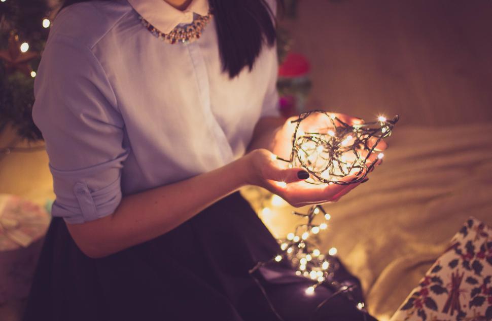 Free Image of Person holding lit fairy lights indoors, festive mood 