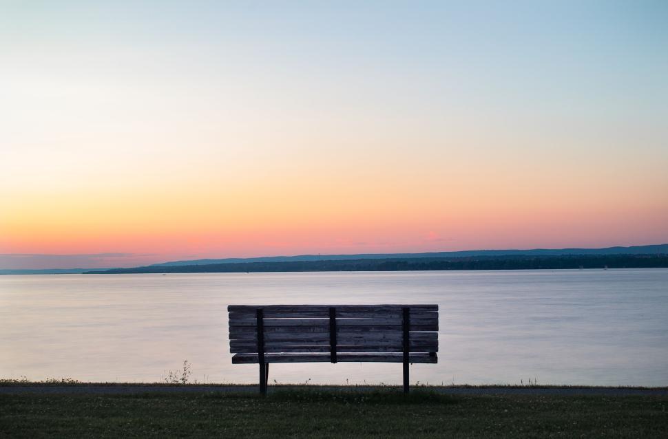 Free Image of Scenic sunset view with empty bench by calm lakeside. 
