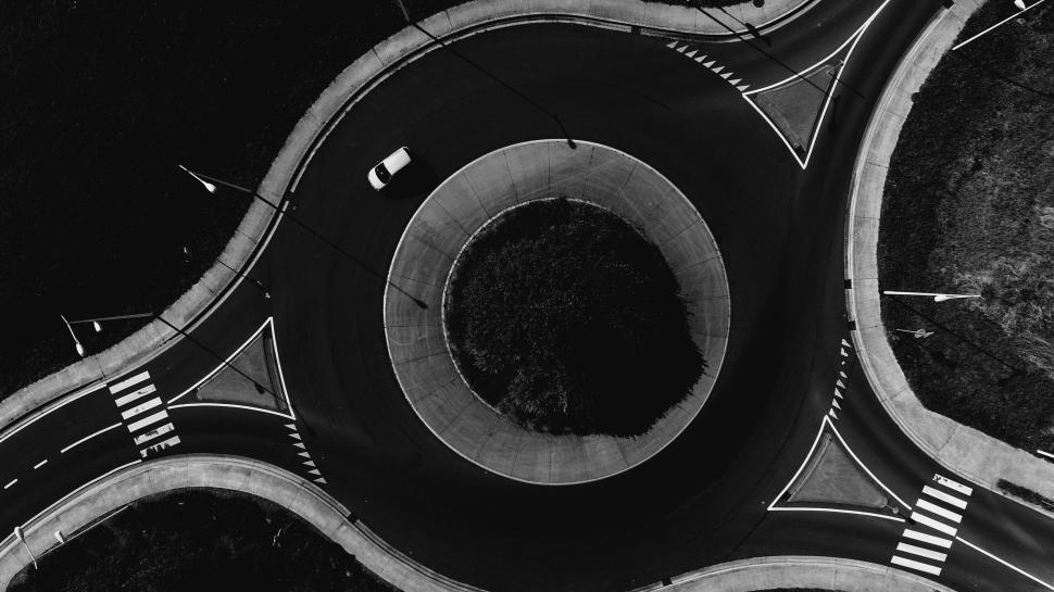 Free Image of Aerial view of roundabout with a single moving car. 