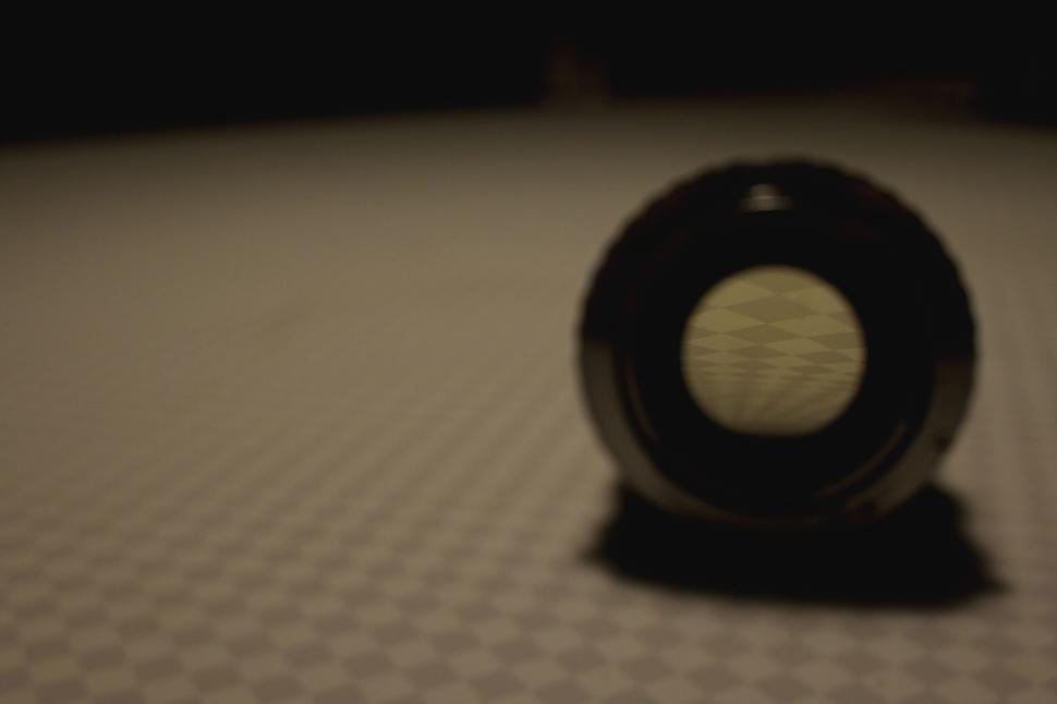 Free Image of Artistic shot of a camera lens on a softly lit surface. 