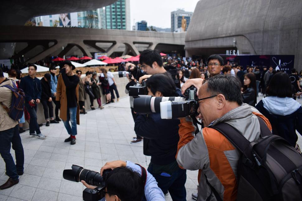 Free Image of Photographers capturing an event in a busy urban area. 