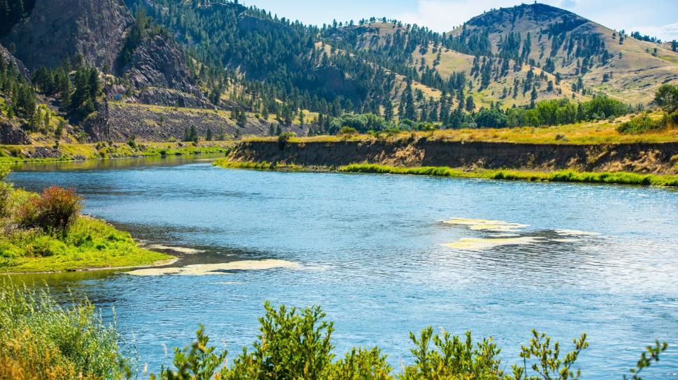 Free Image of Scenic river flowing through mountainous landscape. 