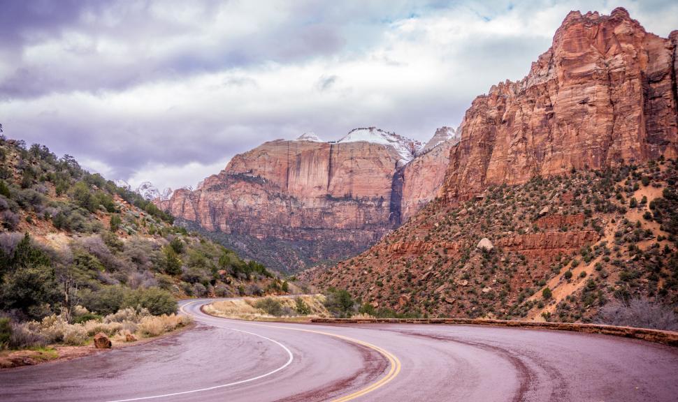 Free Image of Curving road through desert landscape with red rocks 