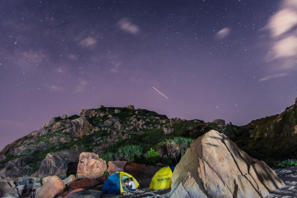 Free Image of Camping under night sky with shooting star in view 