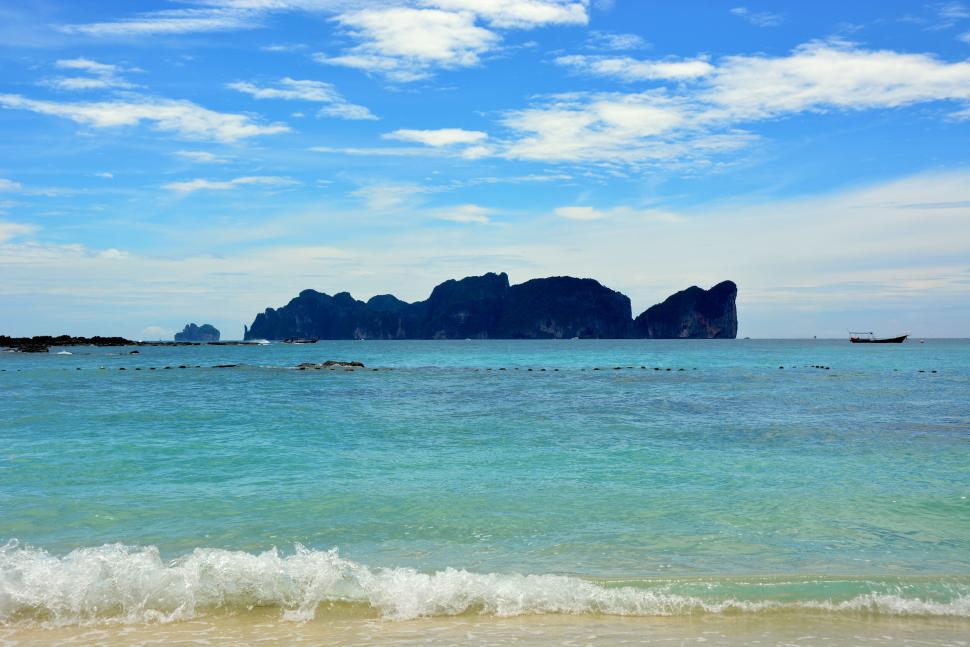 Free Image of Scenic beach with clear waters and islands in distance 