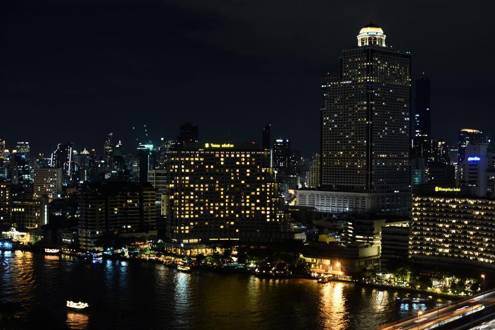 Free Image of Night cityscape featuring illuminated skyscrapers near river 