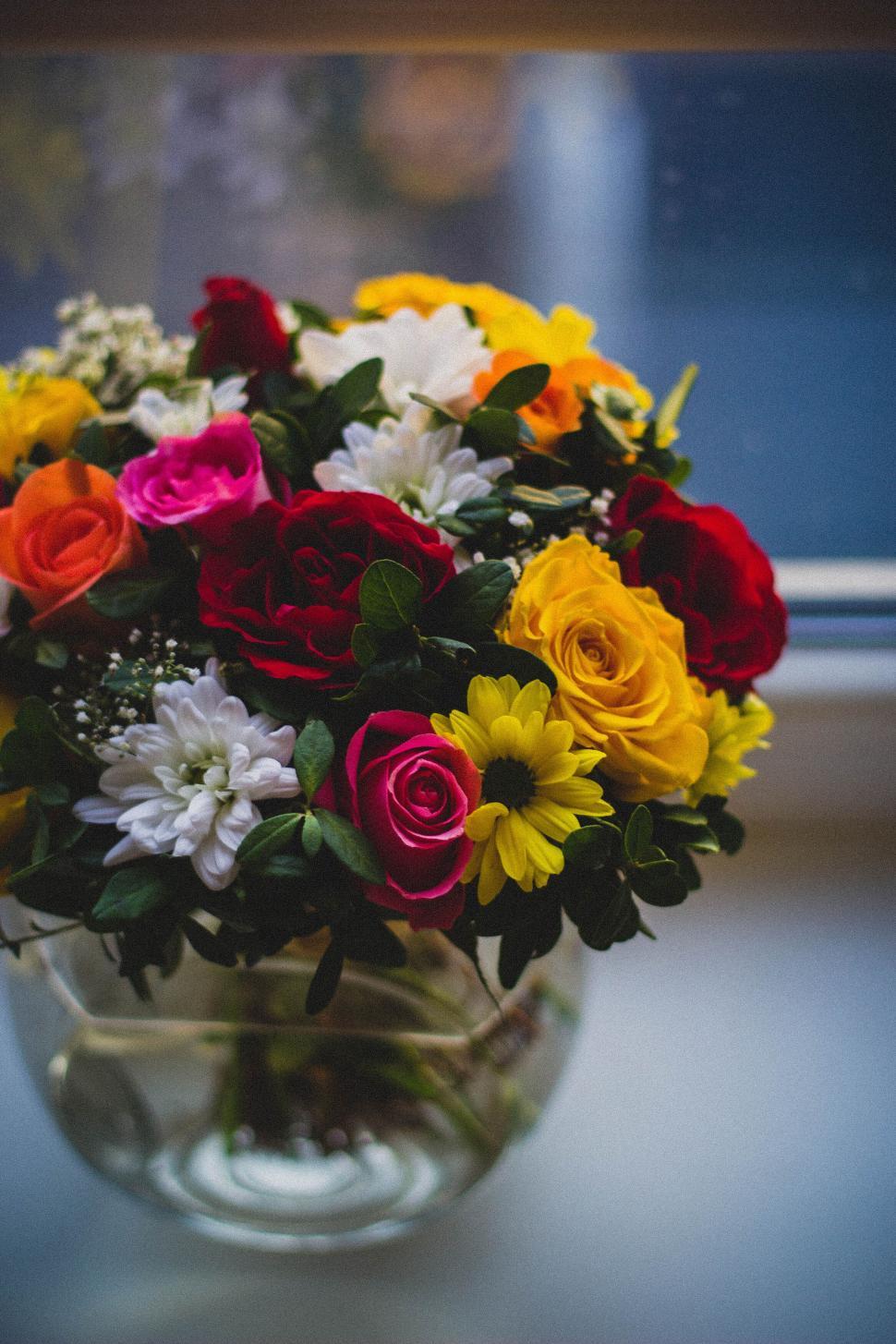 Free Image of Multicolored floral bouquet in a clear glass vase indoors. 