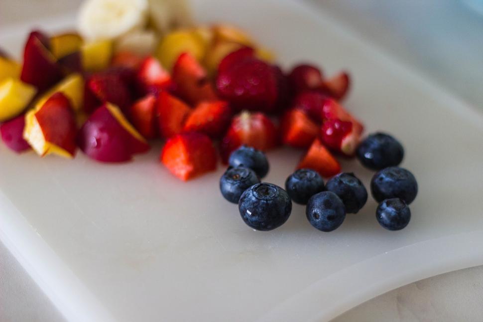 Free Image of Cut fruits including strawberries, blueberries, and bananas. 