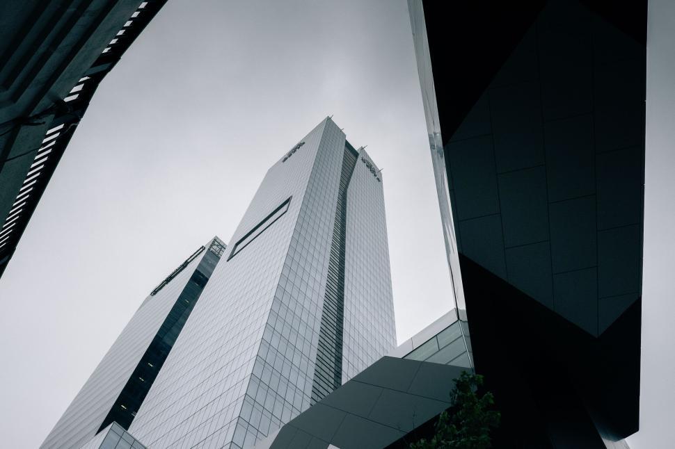 Free Image of Tall skyscrapers under a cloudy sky from below perspective. 