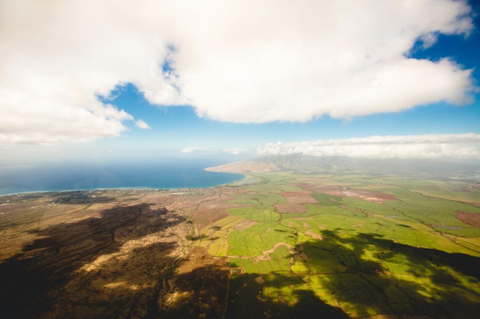 Free Image of Aerial view of coastal landscape with fields and ocean. 