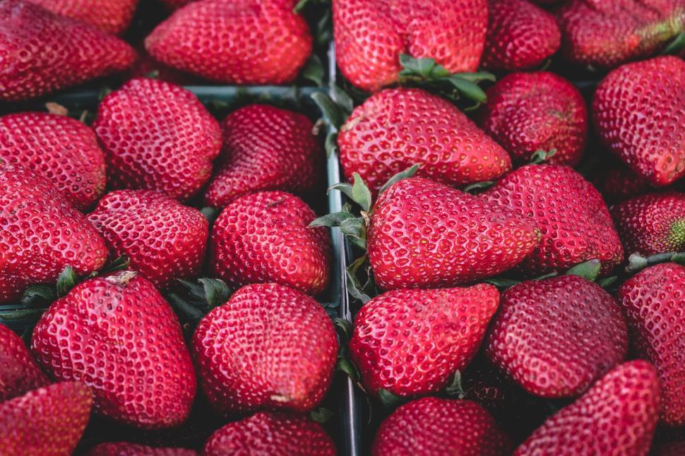 Free Image of Bright red strawberries in a market stall display. 