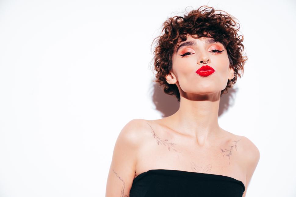 Free Image of Woman with red lips standing with shoulders bared 