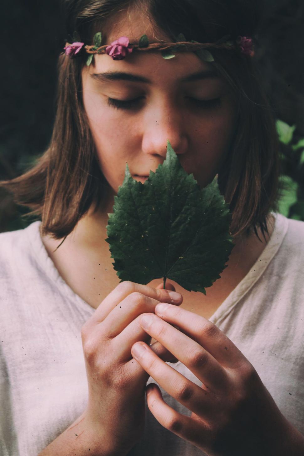 Free Image of Girl with a leaf in hands in a meditative forest moment. 