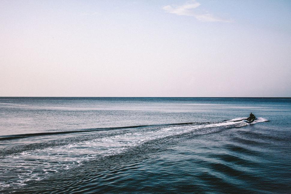 Free Image of Jet ski creating trail on the open sea, under clear sky 