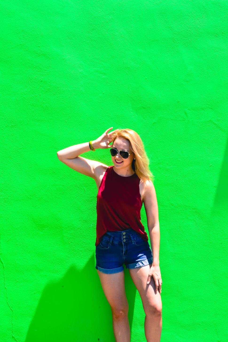 Free Image of Woman against bright green background posing casually 