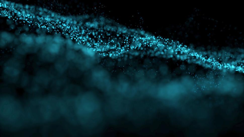 Free Image of An ethereal wave of blue particles floating in the dark 
