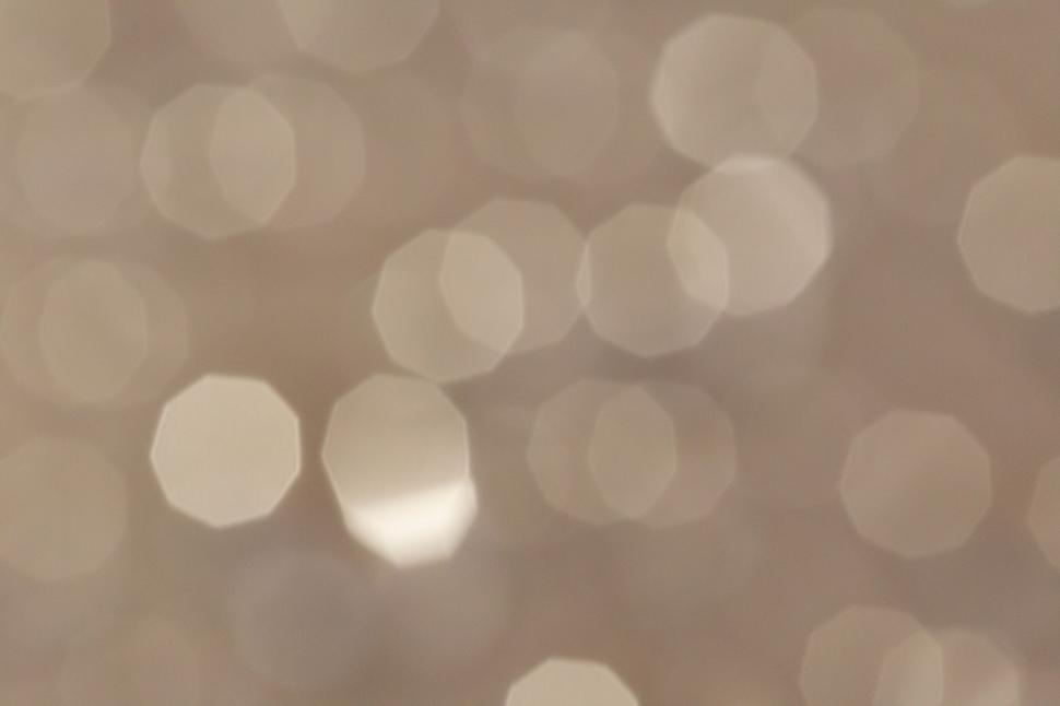 Free Image of Softly blurred, hexagonal light bokeh pattern in beige. 