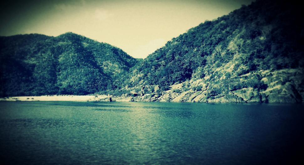 Free Image of Serene lake with mountains covered in lush greenery 