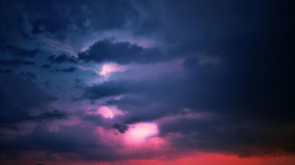 Free Image of Vibrant sky at dusk with dark clouds and pink light 