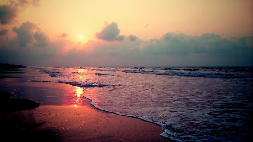 Free Image of Peaceful ocean shoreline at sunset with serene waves 