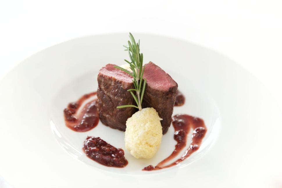 Free Image of Gourmet steak with rosemary and berry sauce garnish 