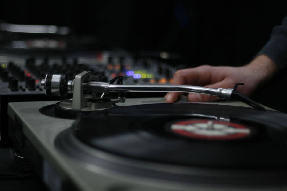Free Image of Close-up of a hand adjusting a turntable needle arm. 