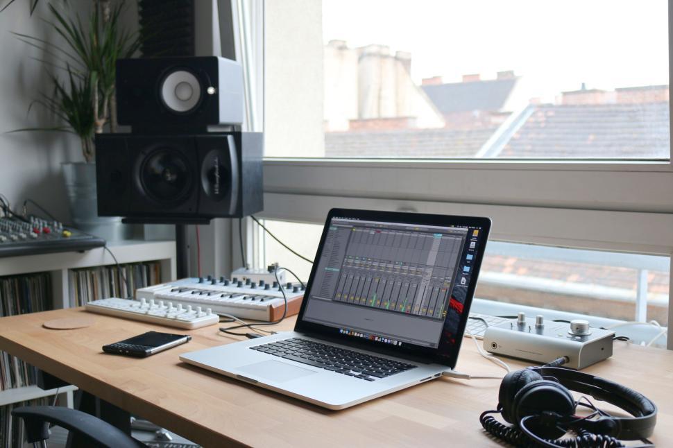 Free Image of Music production setup with a laptop on wooden desk. 