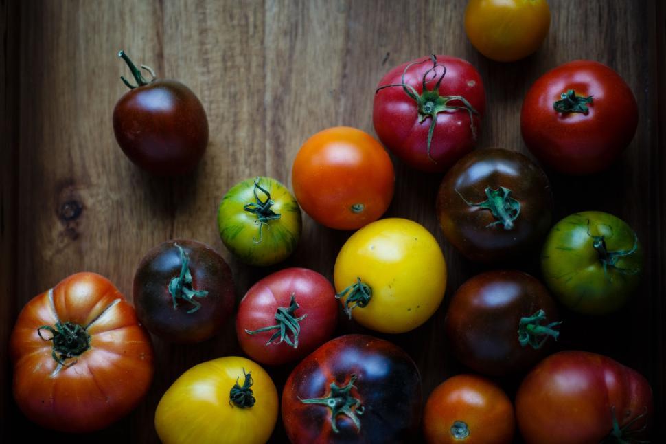 Free Image of Array of colorful tomatoes of various kinds on wood table. 