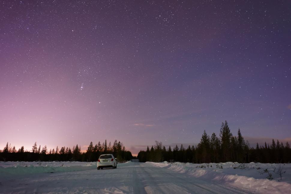 Free Image of Starry night with a road through a snowy forest. 