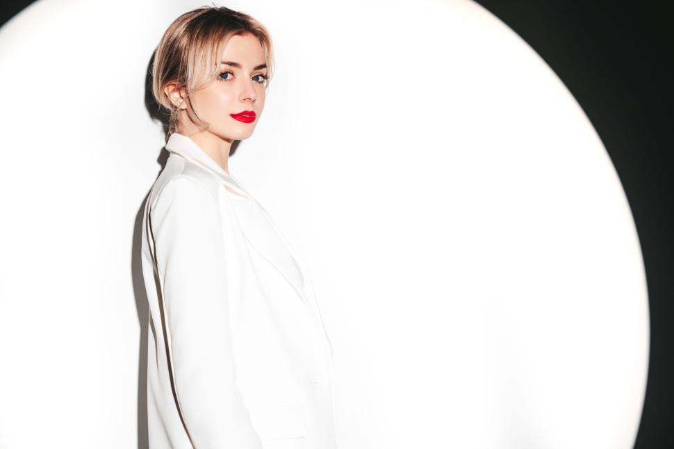 Free Image of Blonde woman in white suit standing confidently 