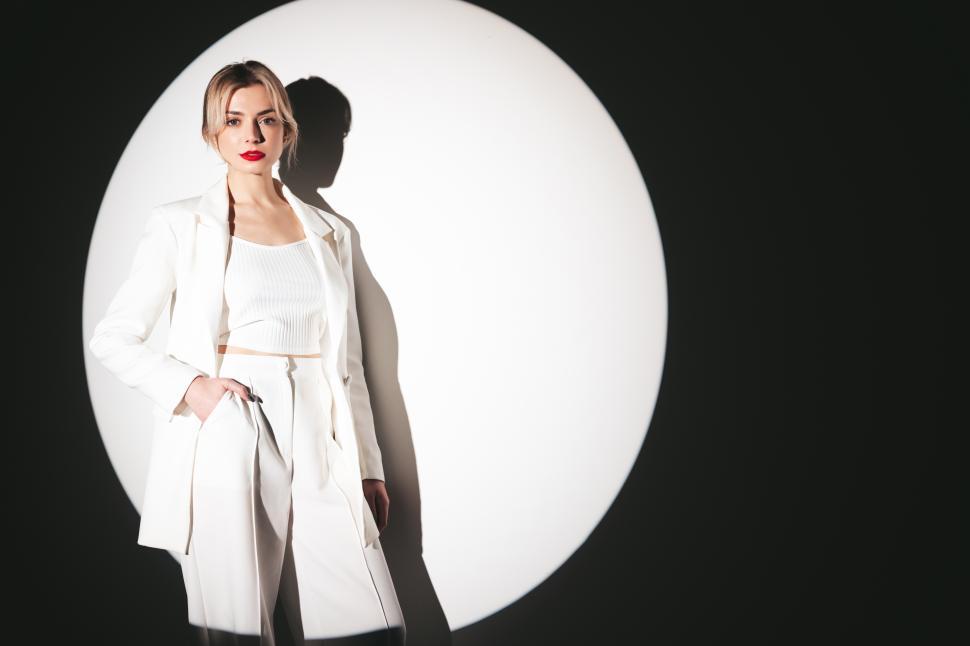 Free Image of Elegant woman posing in stylish white suit outfit. 