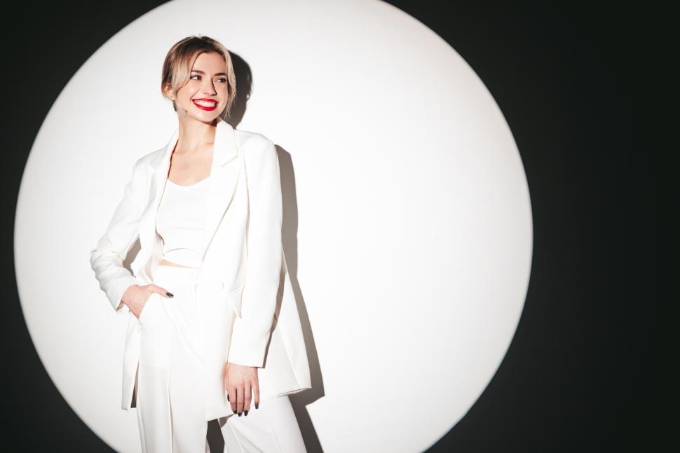 Free Image of Confident woman smiling in stylish white ensemble. 