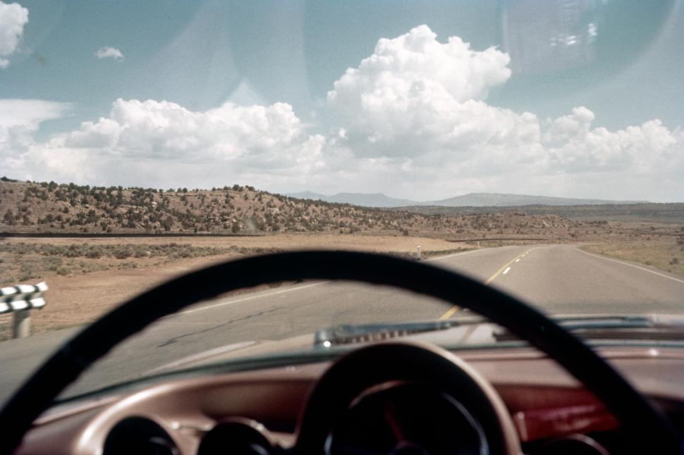 Free Image of Vintage car driving on an open road under clear sky 