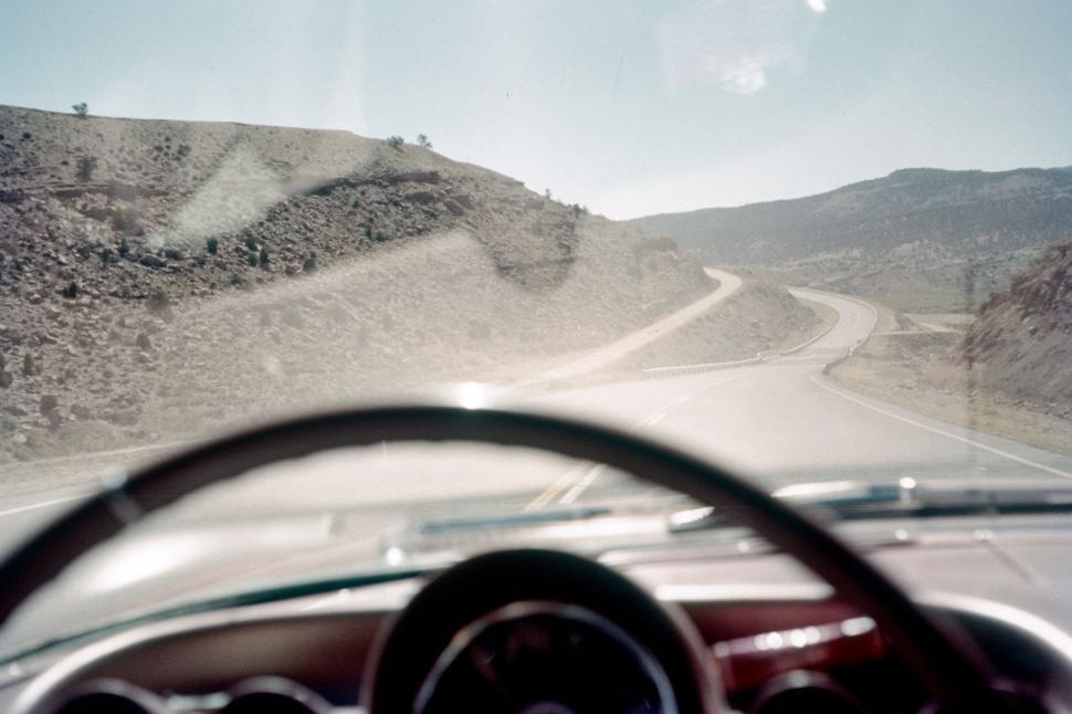 Free Image of Driving through scenic desert road with clear blue sky 