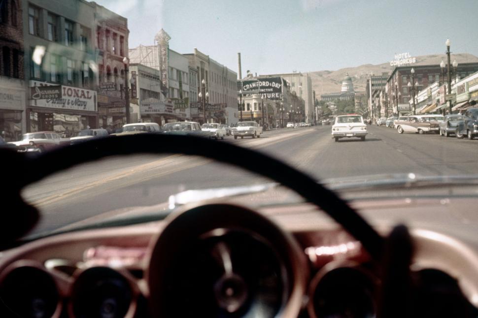 Free Image of Driver s view of bustling city street with buildings. 