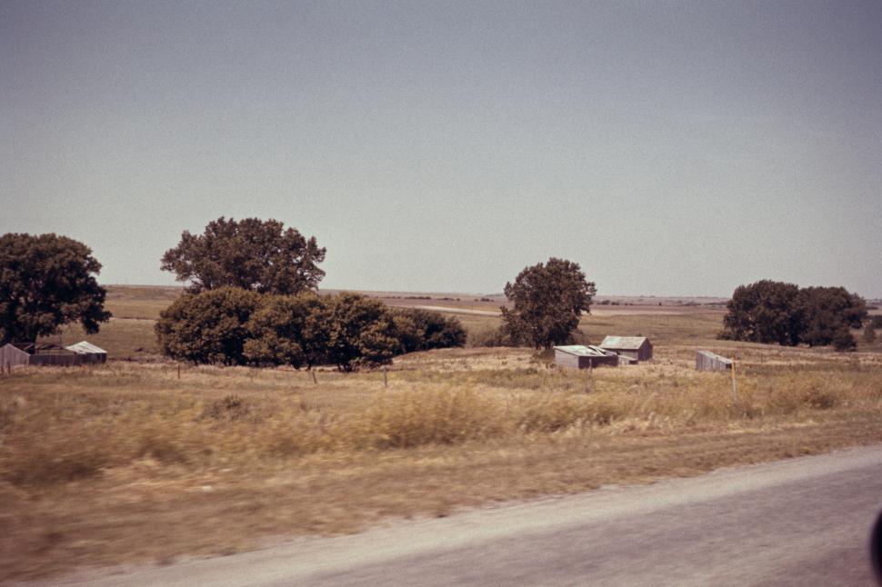 Free Image of Rural landscape with trees, fields, and rustic old barns. 