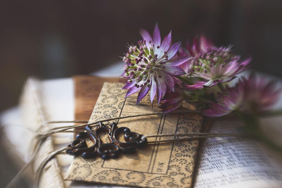 Free Image of Purple flowers and ornate cards tied by brown string 