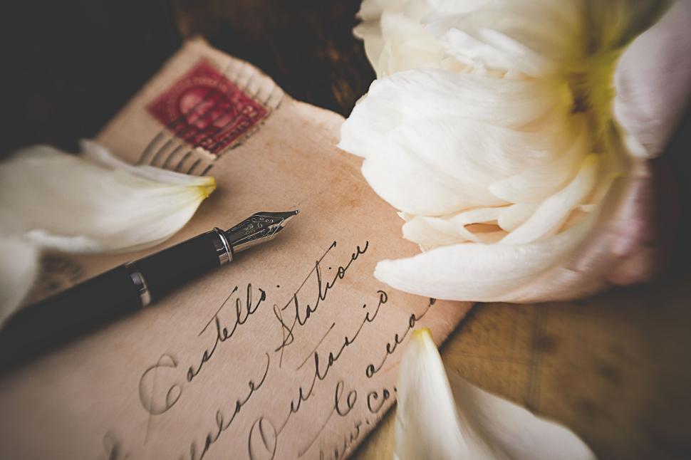 Free Image of Old handwritten letter with a fountain pen and petals 