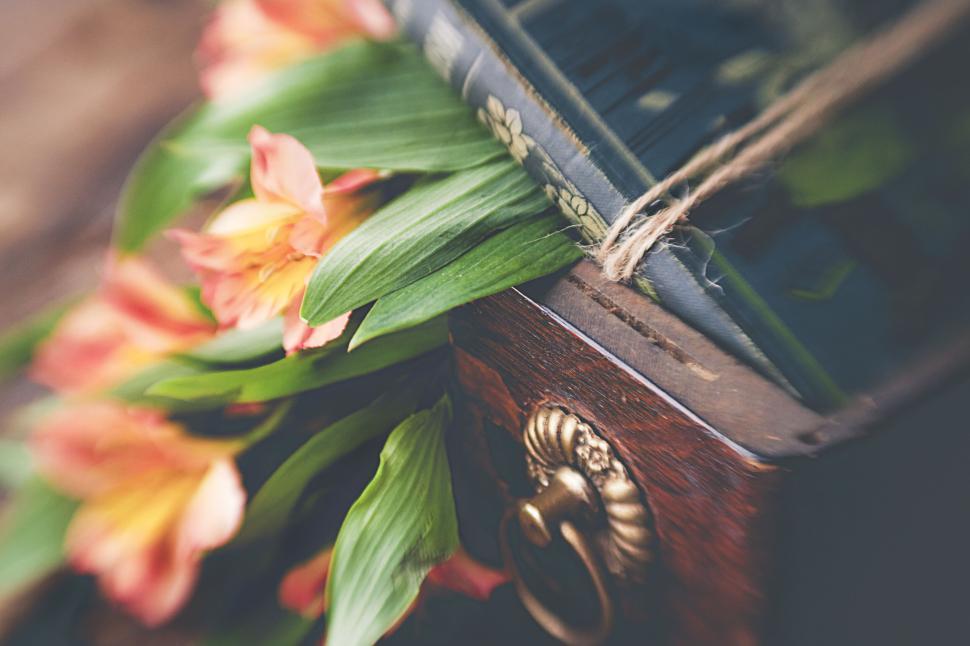 Free Image of Floral arrangement with books on a wooden surface 