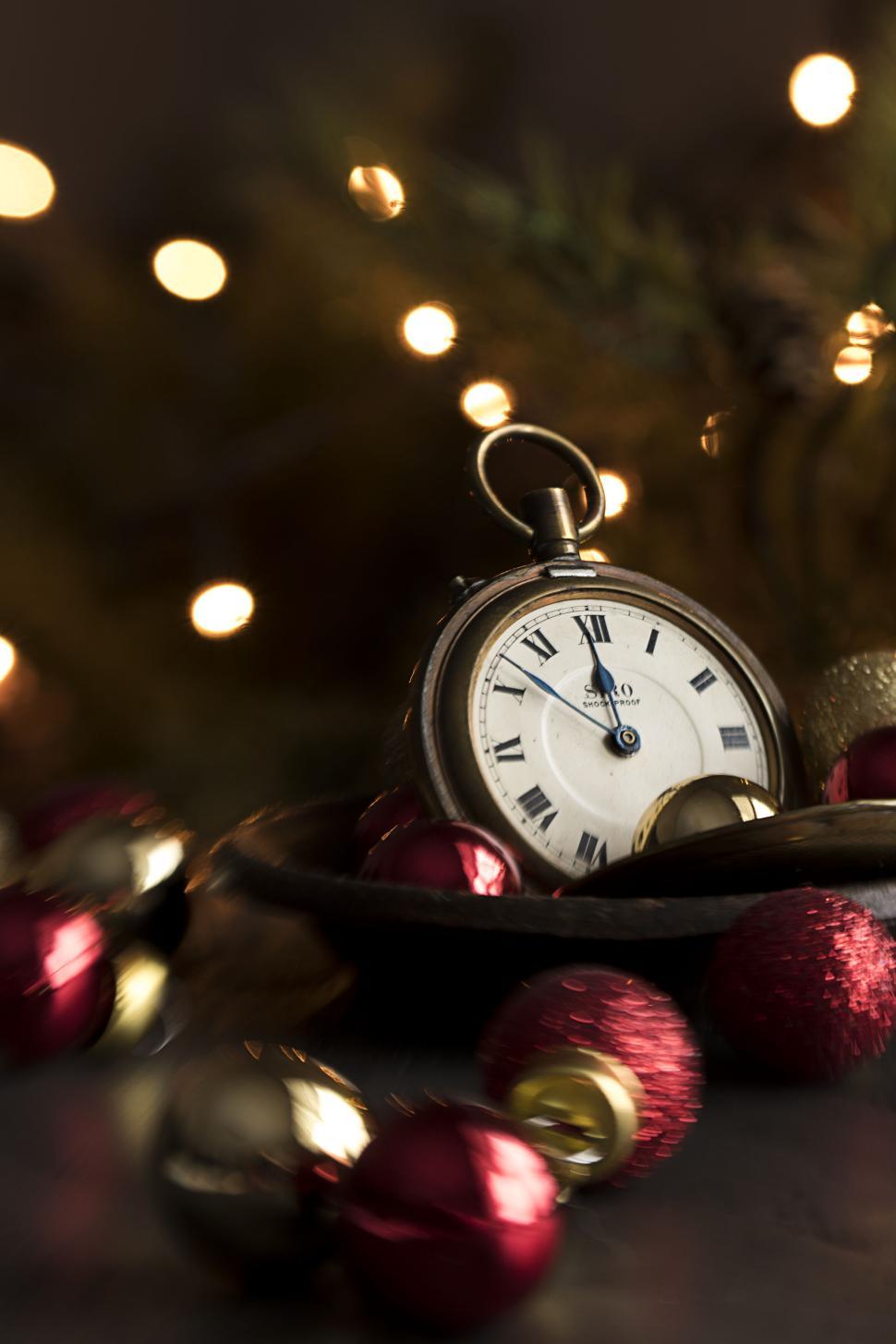Free Image of Vintage pocket watch amid Christmas baubles and lights 