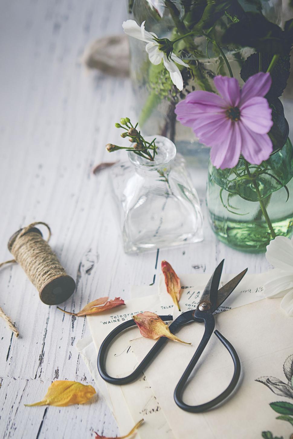 Free Image of Cutting scissors and floral arrangement on wooden table 