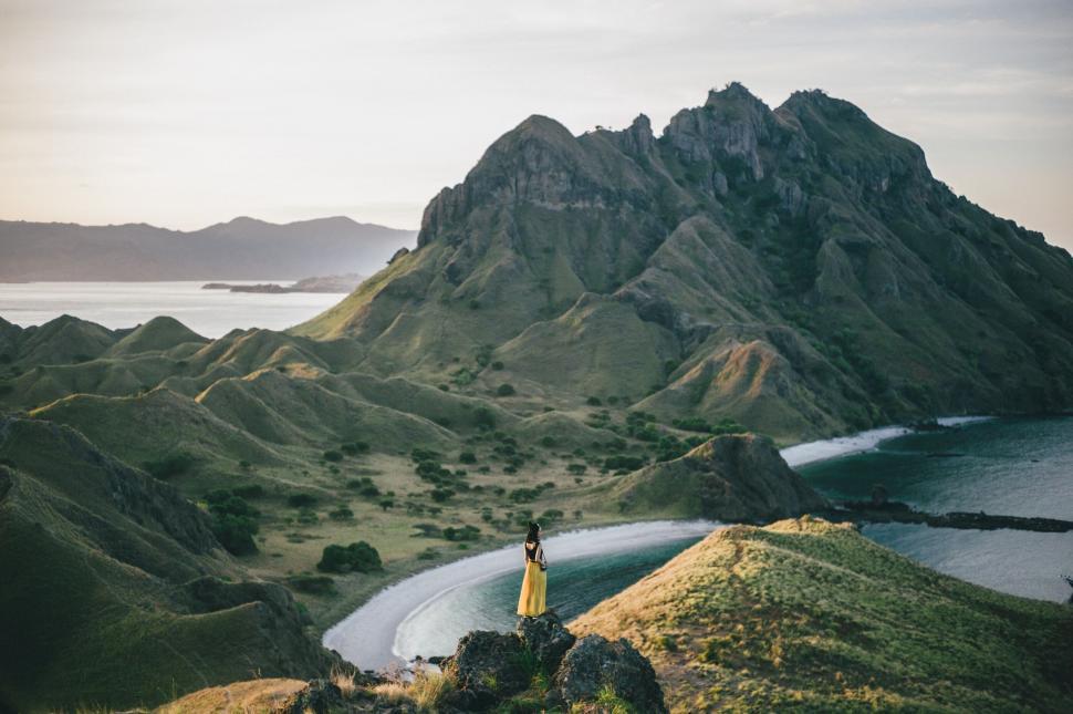 Free Image of Person walking on scenic coastal hills at sunrise 