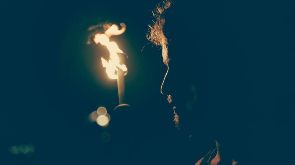 Free Image of Silhouette of a man with a burning torch at twilight. 