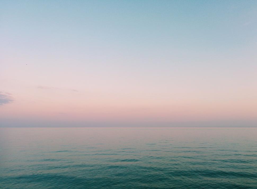 Free Image of Serene ocean with pastel sky creating a calming scene 